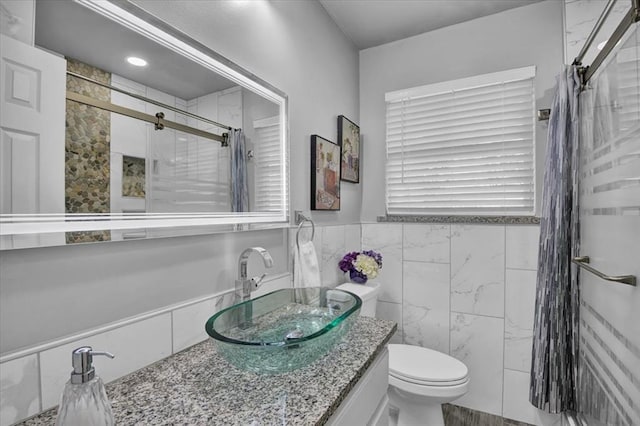 bathroom featuring vanity, toilet, tile walls, and an enclosed shower