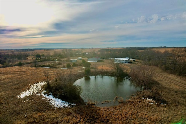 aerial view at dusk featuring a water view