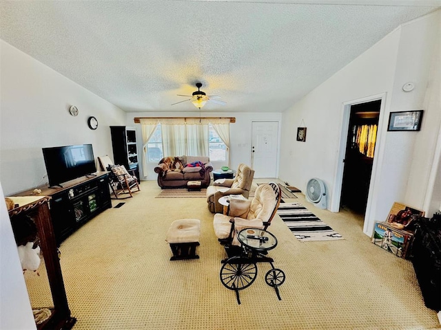 living room featuring ceiling fan, light colored carpet, and a textured ceiling