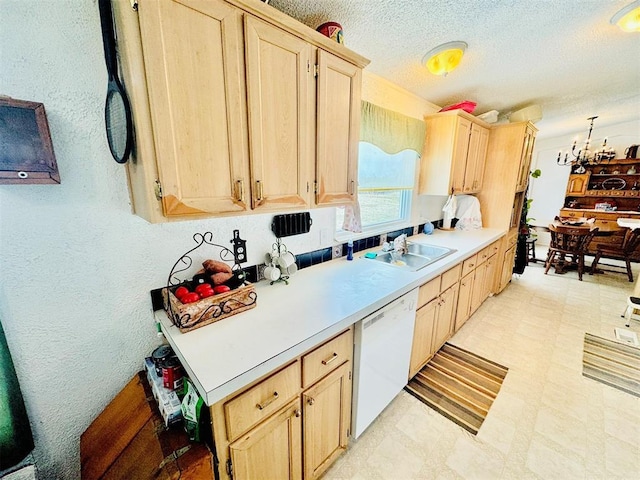 kitchen with sink, light brown cabinetry, white dishwasher, and a textured ceiling