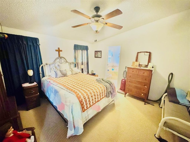 bedroom with ceiling fan, ensuite bathroom, a textured ceiling, and carpet floors