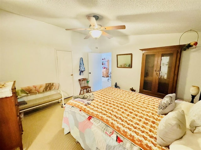 carpeted bedroom featuring a textured ceiling and ceiling fan