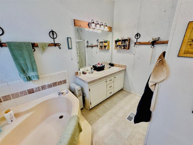 bathroom with radiator heating unit, a tub to relax in, and vanity