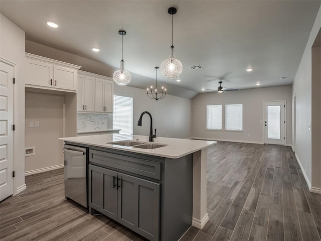 kitchen with a sink, visible vents, ceiling fan with notable chandelier, gray cabinetry, and dishwasher