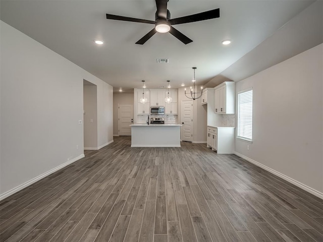 unfurnished living room with a ceiling fan, wood finished floors, baseboards, visible vents, and recessed lighting
