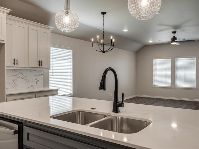 kitchen with recessed lighting, vaulted ceiling, a sink, decorative backsplash, and hanging light fixtures