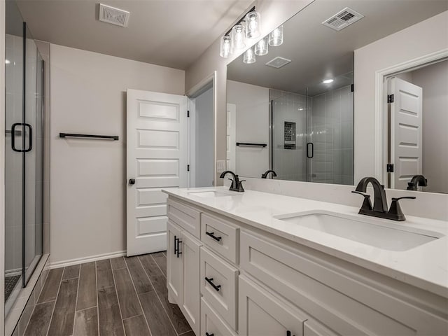 bathroom featuring wood tiled floor, a sink, and visible vents
