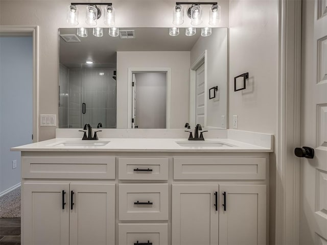 bathroom featuring a shower stall, a sink, visible vents, and double vanity