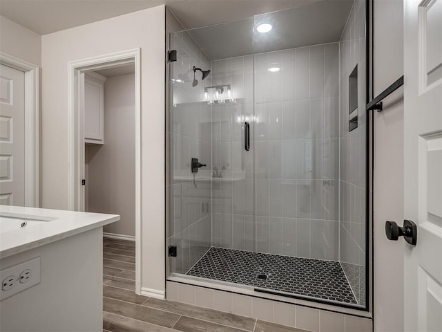 bathroom with recessed lighting, a shower stall, vanity, baseboards, and wood finish floors