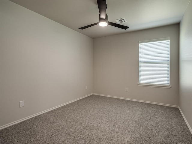empty room with baseboards, a ceiling fan, visible vents, and carpet flooring