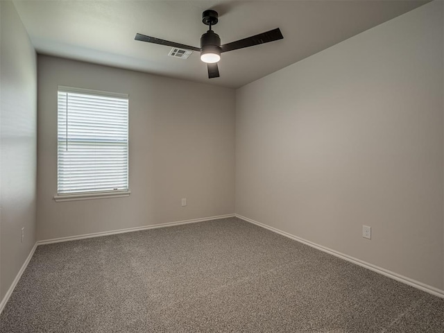 empty room with visible vents, carpet flooring, baseboards, and ceiling fan