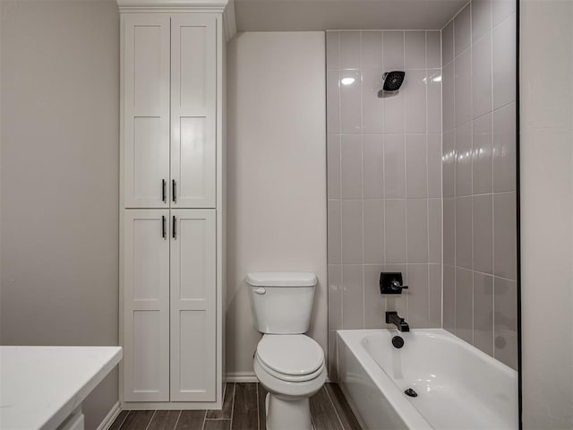 full bath featuring toilet, wood tiled floor, a closet, shower / bath combination, and baseboards