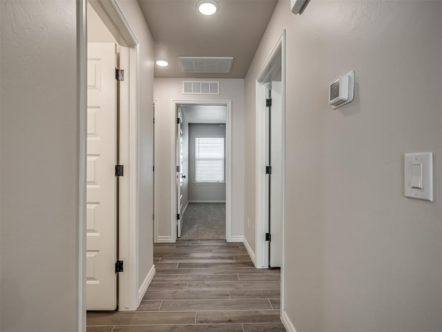 corridor with baseboards, dark wood-type flooring, visible vents, and recessed lighting