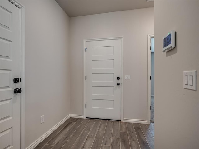 doorway to outside with baseboards and dark wood-style flooring