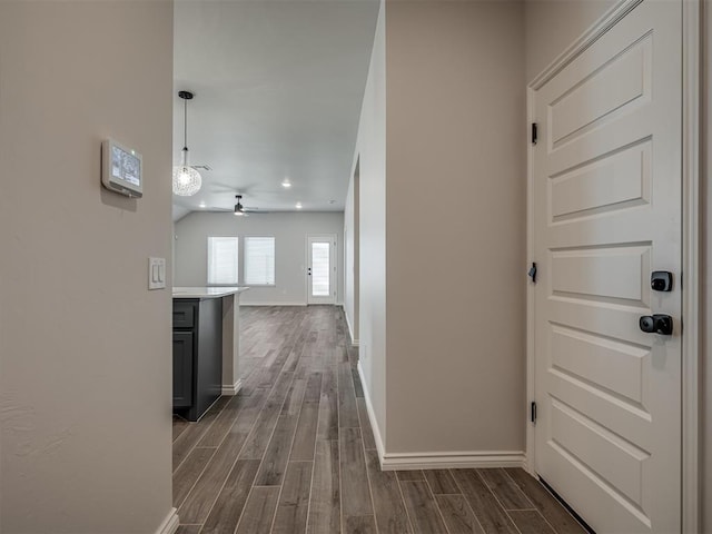 hallway featuring baseboards, dark wood-style flooring, and recessed lighting