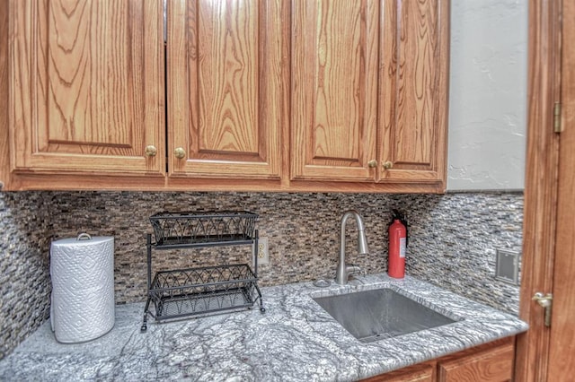 344 Millbrook Dr, Norman, OK 73072 - kitchen with light stone countertops, sink, and backsplash