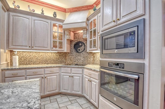 344 Millbrook Dr, Norman, OK 73072 - kitchen with light stone counters, appliances with stainless steel finishes, custom range hood, and backsplash