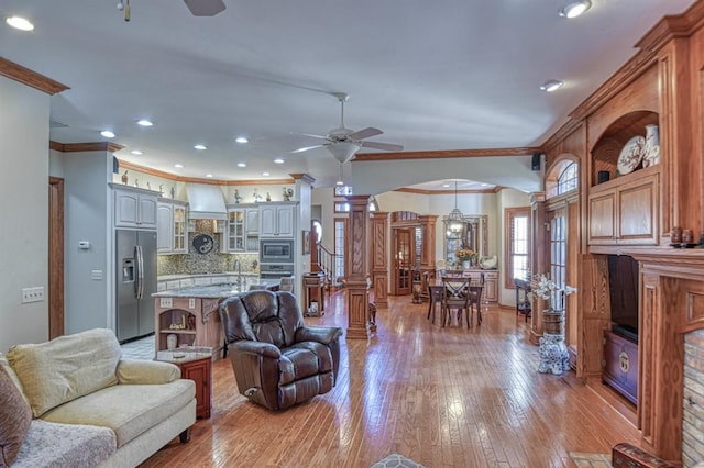 344 Millbrook Dr, Norman, OK 73072 - living room with ornate columns, sink, ceiling fan, crown molding, and light wood-type flooring