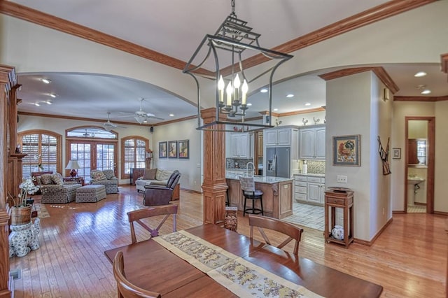 344 Millbrook Dr, Norman, OK 73072 - dining space featuring sink, crown molding, ceiling fan, light wood-type flooring, and ornate columns