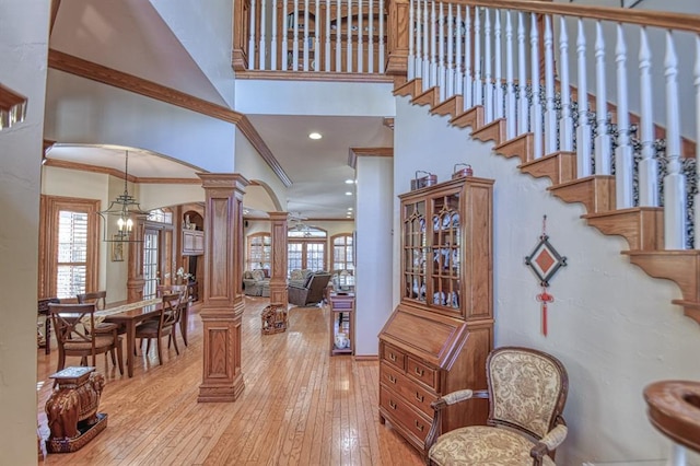 344 Millbrook Dr, Norman, OK 73072 - foyer with a towering ceiling, a notable chandelier, ornamental molding, light hardwood / wood-style floors, and ornate columns