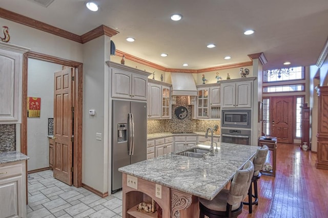 344 Millbrook Dr, Norman, OK 73072 - kitchen featuring sink, a breakfast bar, a kitchen island with sink, stainless steel appliances, and custom exhaust hood