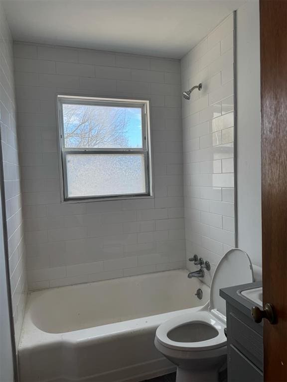 full bathroom featuring tiled shower / bath, vanity, and toilet