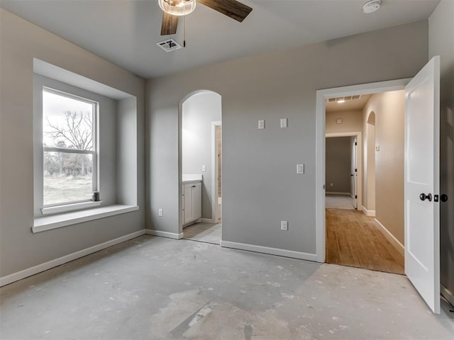 unfurnished bedroom featuring ceiling fan and ensuite bath