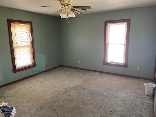 carpeted spare room featuring ceiling fan