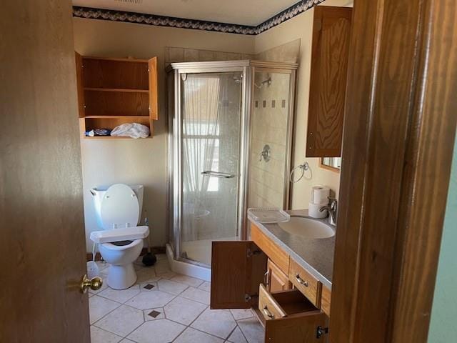 bathroom featuring tile patterned floors, toilet, a shower with door, and vanity