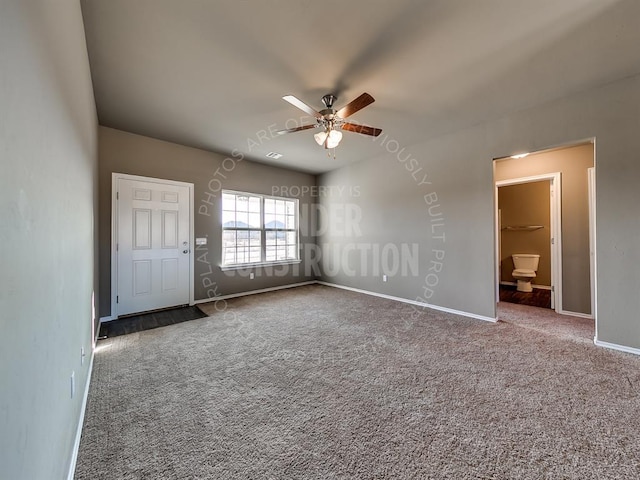 interior space with ceiling fan, carpet, and ensuite bathroom