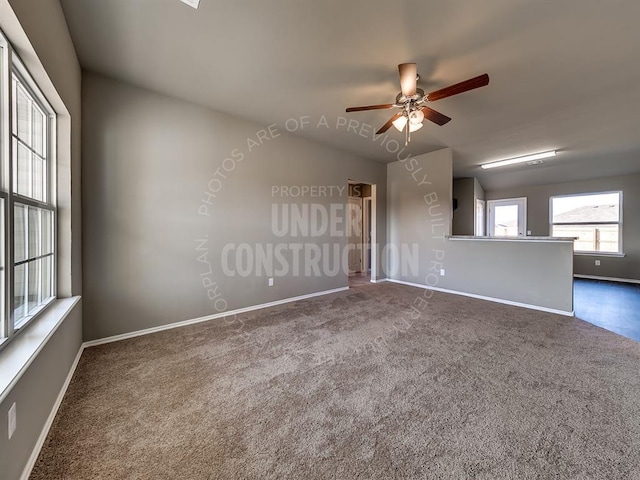 unfurnished room featuring ceiling fan and dark colored carpet