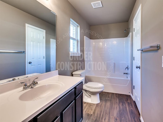 full bathroom with shower / bath combination, hardwood / wood-style floors, toilet, and vanity