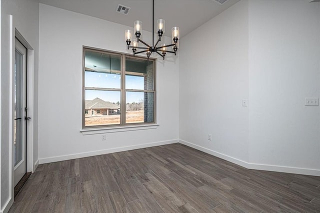 unfurnished dining area featuring a chandelier and dark hardwood / wood-style floors