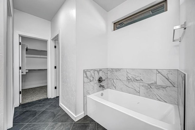 bathroom with a bath and tile patterned flooring