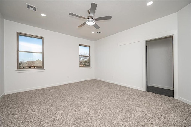 carpeted spare room featuring ceiling fan