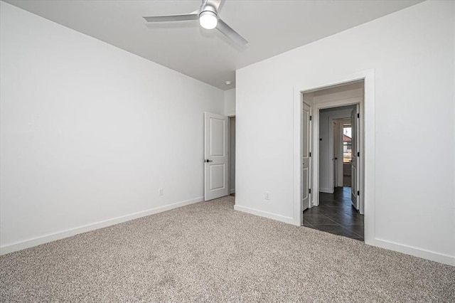 unfurnished bedroom with ceiling fan and dark carpet