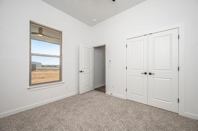 unfurnished bedroom featuring light colored carpet and a closet