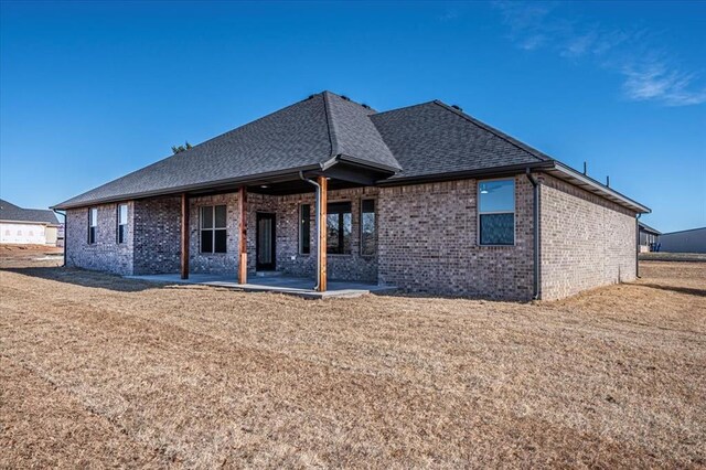 back of house with a yard and a patio