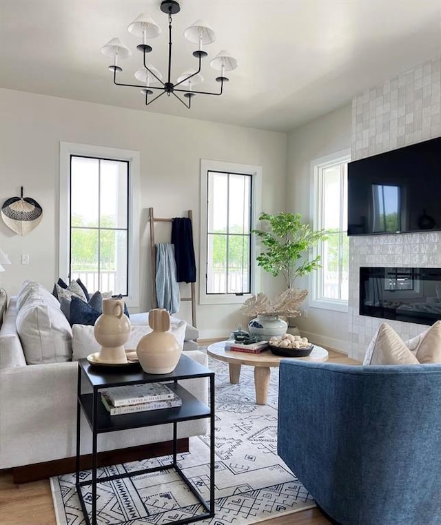 living room featuring hardwood / wood-style floors, a notable chandelier, and a fireplace