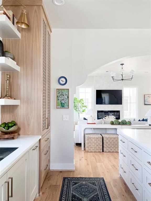 kitchen with white cabinets, light hardwood / wood-style flooring, a notable chandelier, and plenty of natural light