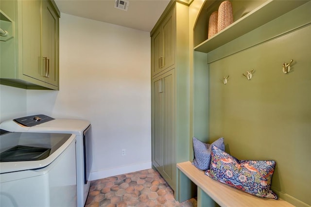 laundry room featuring cabinets, light tile patterned floors, and washing machine and clothes dryer