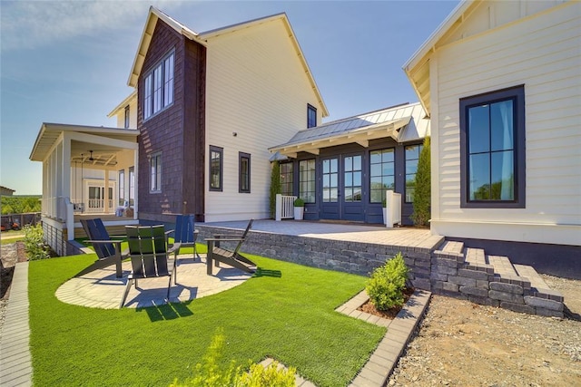 back of house featuring ceiling fan, a yard, and a patio