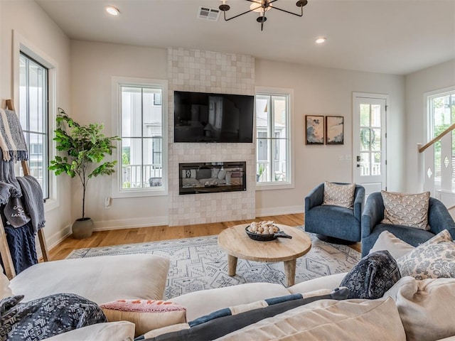 56 Center Ln, Carlton Landing, OK 2023 - living area featuring wood finished floors, a fireplace, recessed lighting, and a chandelier