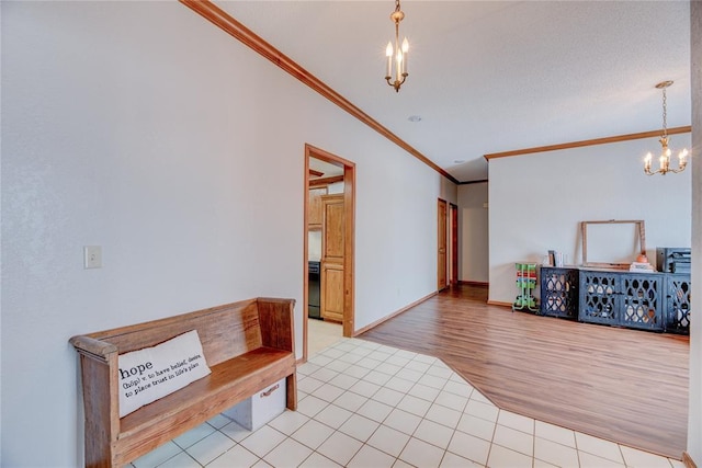 entryway featuring an inviting chandelier, light wood-type flooring, and ornamental molding