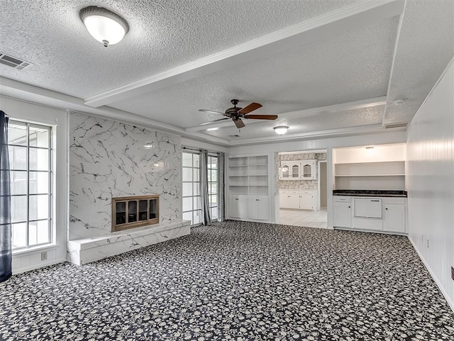 unfurnished living room featuring a healthy amount of sunlight, a fireplace, and a textured ceiling