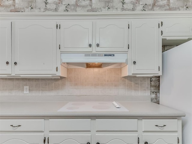 kitchen with tasteful backsplash, white cabinetry, and white cooktop