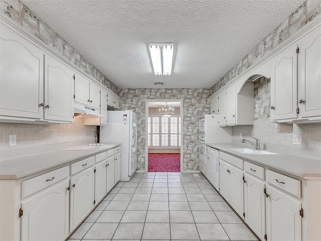 kitchen featuring tasteful backsplash, white appliances, sink, and white cabinets