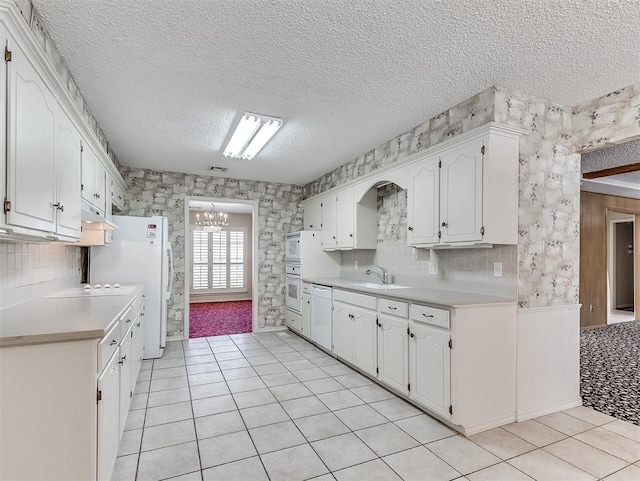 kitchen featuring white cabinetry, white appliances, decorative backsplash, and a textured ceiling