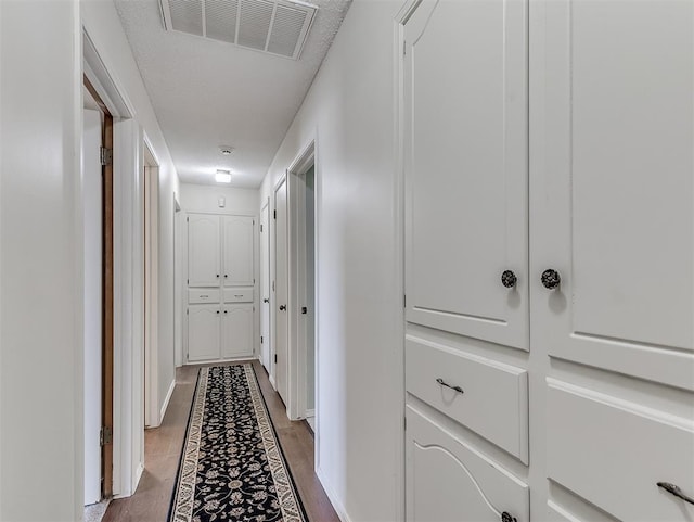 hall featuring dark hardwood / wood-style floors and a textured ceiling