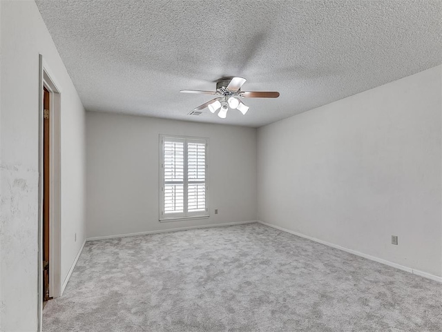 carpeted spare room featuring a textured ceiling and ceiling fan